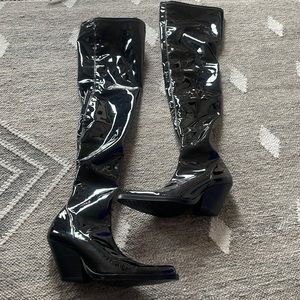 Black heeled over-the-knee boots.Tall stretch shaft. Cowboy heel latex material